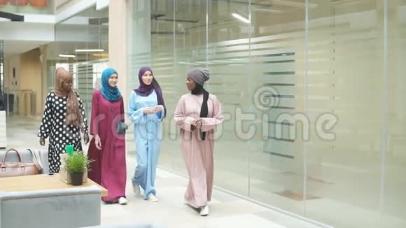一群四个穆斯林多民族女孩在商务中心聊天散步视频的预览图