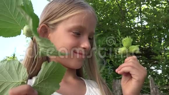 大自然中的儿童观黑榛果户外活动校园女孩面对水果视频的预览图