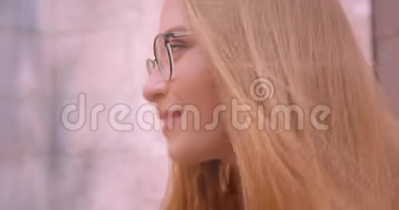 一位年轻迷人的白种人女性戴着长长的眼镜看着镜头开心地笑着视频的预览图