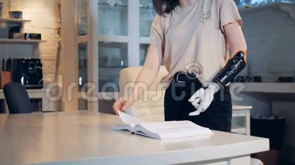一个女孩正在用假肢书页滚动真正的机器人人类般的手臂视频的预览图