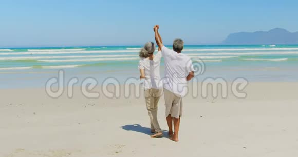 浪漫活跃的老年非裔美国夫妇在海滩上跳舞的侧面景色视频的预览图