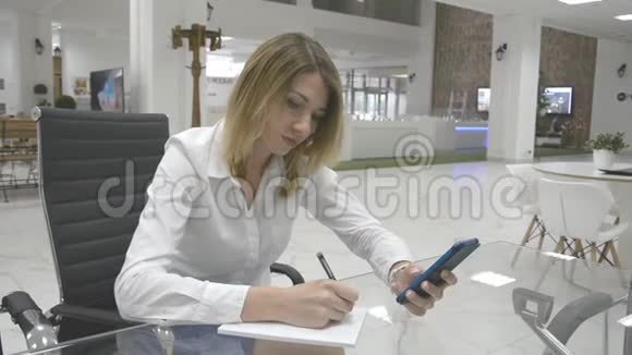 Bussines概念商务女性从电话中做笔记视频的预览图