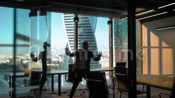 独舞的员工剪影在现代商务办公室玻璃墙和门视频的预览图