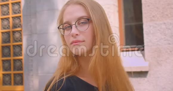 年轻迷人的白种人女性戴着长头发的眼镜看着镜头开心地笑着视频的预览图