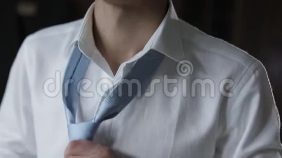 英俊的新郎系着他的蓝色领结结婚的早晨商人视频的预览图
