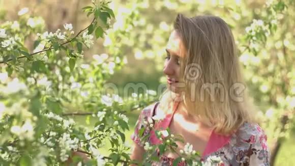 年轻的女人和一棵开花的树视频的预览图
