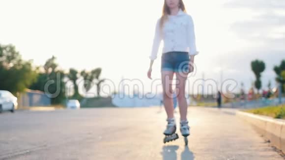一个害羞苗条的少女在公园溜冰视频的预览图