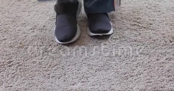 在软地毯上脱掉运动鞋的人视频的预览图
