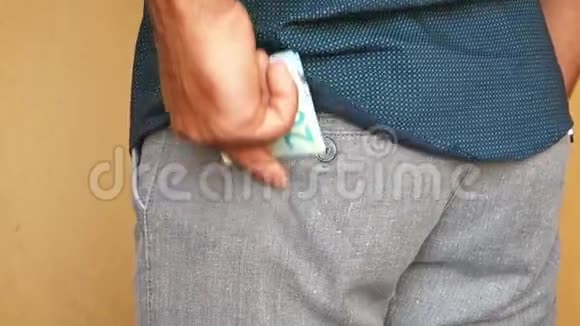 一个男人把欧元钞票放在裤子的后口袋里一个人把钱藏在口袋里视频的预览图