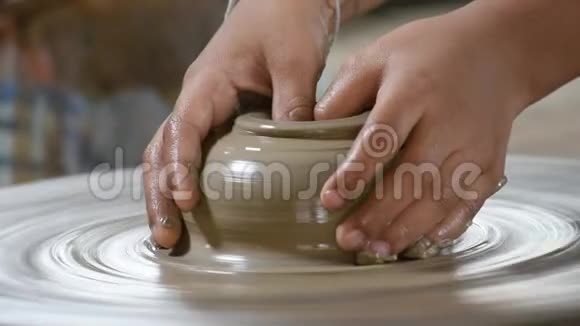 手指是一个旋转托盘上的粘土罐视频的预览图