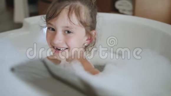 小女孩洗澡时玩淋浴附件洗澡的快乐女孩子积极的小女孩视频的预览图