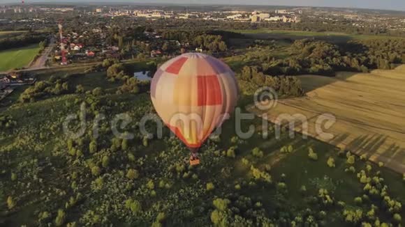 大热气球飞在小镇附近的绿色森林里视频的预览图