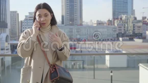 成功的高加索女人站在城市街道上打电话的肖像漂亮的黑发女商人视频的预览图
