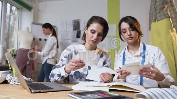 两个女裁缝在工作期间的肖像与服装草图视频的预览图
