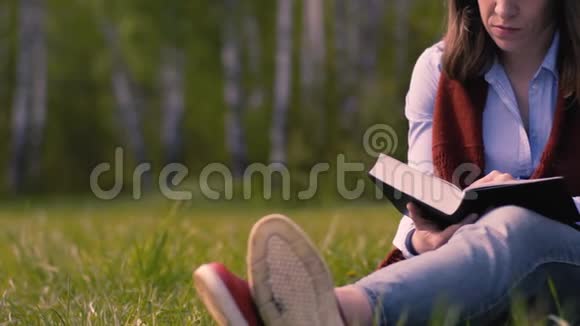 女人在公园里读一本书视频的预览图
