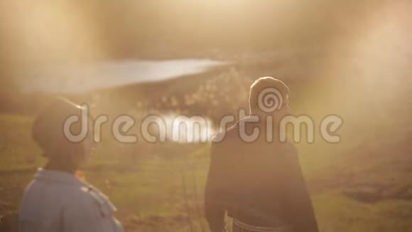 日落时分在公园散步的年轻情侣一个女孩跳到她的爱人的背上男人把她抱下来视频的预览图