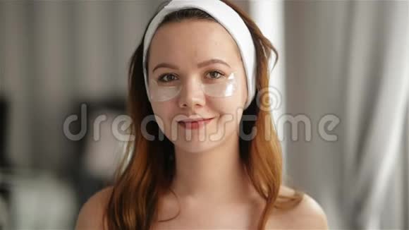 年轻的微笑女孩的肖像眼睛下面的脸上有补丁化妆美容理念护肤水疗视频的预览图