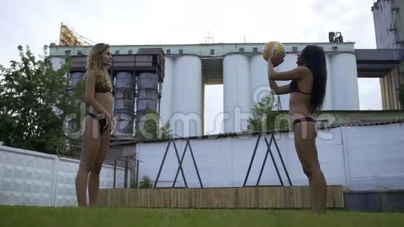 两个漂亮的女孩在户外比基尼打排球剩下的两个女朋友穿泳衣慢动作视频的预览图