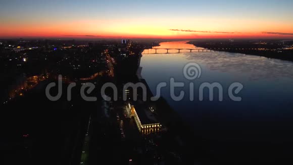 日落时用一座桥在一条宽阔的河流上俯瞰夜晚的城市日落反映在water4kCopy上视频的预览图
