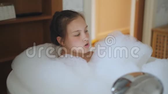 一个十几岁的女孩在浴缸里满是泡沫放松视频的预览图