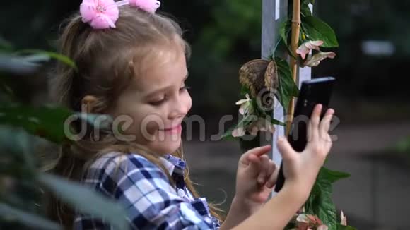 一个女孩用蝴蝶自拍婴儿在屏幕前摆姿势4K慢慢视频的预览图