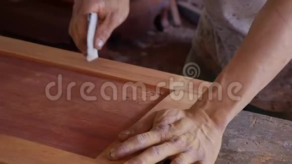 乔纳用砂纸在桌子上手工打磨木头工艺厂正品施工工具的特写慢慢视频的预览图