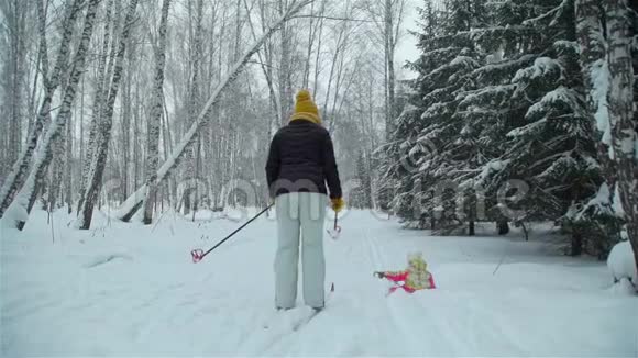 在雪地里和妈妈一起滑雪的女孩视频的预览图