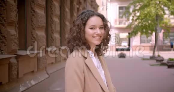 年轻的白种人女学生在镜头前站在室外开心地微笑的特写镜头视频的预览图