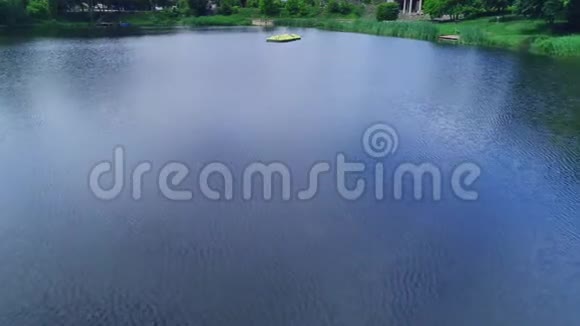 在风景优美的背景下划艇在湖上漂浮在绿色的公园中放大和缩小4K视频的预览图