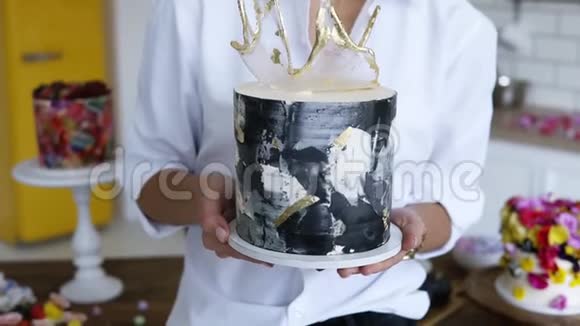 女性糖果师在她的厨房里呈现装饰蛋糕用伸出的手拿着它蛋糕的目标焦点视频的预览图
