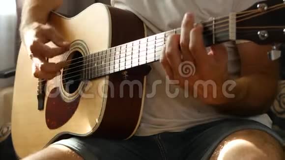 这位音乐家用黄色的吉他弹奏节奏很快一缕光线落在吉他的手指和脖子上视频的预览图