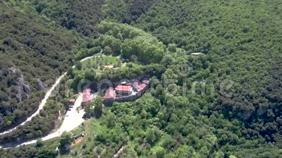 在森林中的一座山上鸟瞰施洗者圣约翰修道院由无人机向下移动视频的预览图