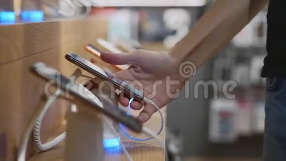 无法辨认的人在电子商店里选择智能手机视频的预览图