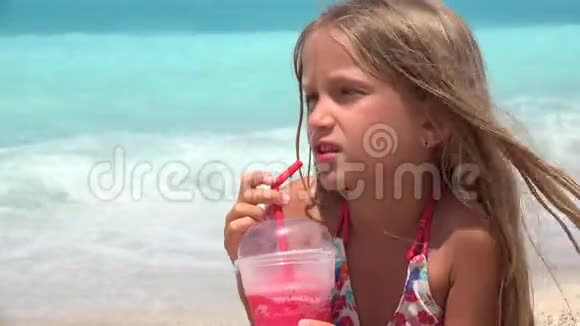 海滩上的儿童肖像喝果汁海滩上的口渴女孩的脸视频的预览图