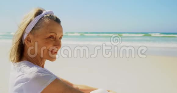 活跃的高加索族女性在海滩上做瑜伽的侧视图视频的预览图