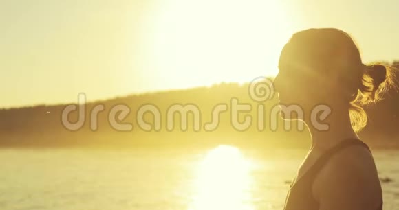 黄花夕阳女子坐在河畔码头的荷花位上沉思侧视视频的预览图