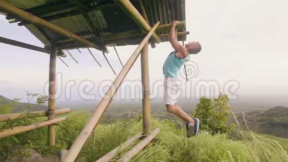 强壮的人在山上和高原覆盖热带森林的木棒上训练拉力运动体育健将视频的预览图