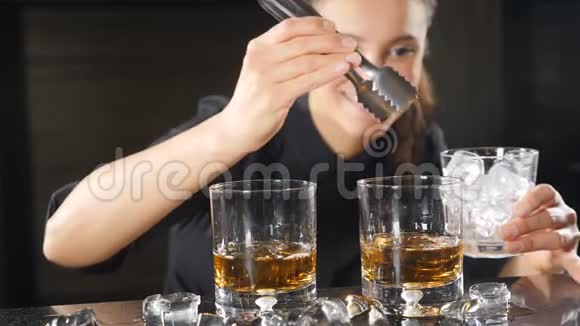 女调酒师将冰缓慢地放入酒精饮料的特写镜头准备有灵气的鸡尾酒视频的预览图