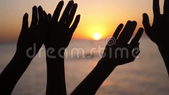 幸福的家庭举手双手举在空中在夕阳的天空上剪影视频的预览图