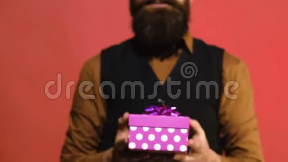 红色背景上男人手中的粉色礼盒人赠送节日礼物情人节概念视频的预览图