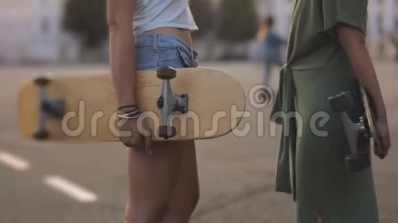 起重机射击欧洲小镇街头阳光下玩滑板的两个少女朋友的照片视频的预览图