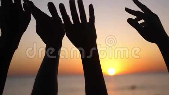 幸福的家庭举手双手举在空中在夕阳的天空上剪影视频的预览图