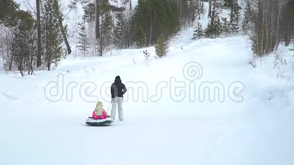 母亲和女儿把雪管拉到山上视频的预览图