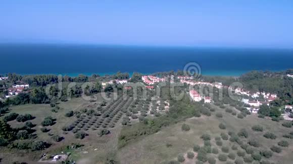 空中俯瞰绿松石和蓝色海岸和游客之家在科罗皮吉哈基迪基希腊向上移动无人机视频的预览图