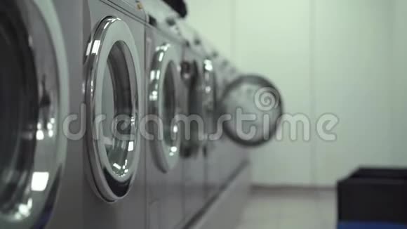 洗衣店里的一排工作洗衣机慢动作中弹视频的预览图