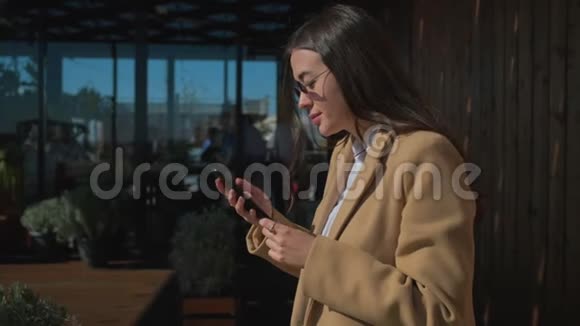 可爱的城市女孩与智能手机咖啡厅视频的预览图