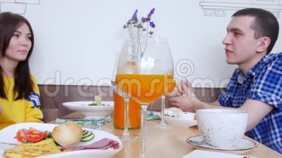 一群朋友坐在咖啡馆里聊天前景是一杯橙汁视频的预览图