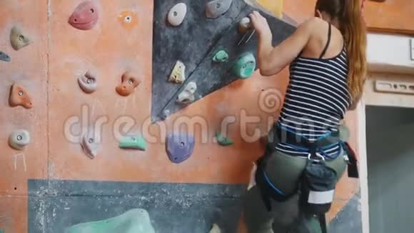 一堆石头一个女人努力地爬上岩石墙视频的预览图