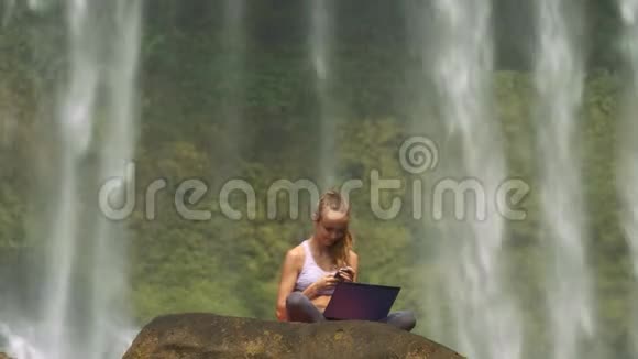 在水中的悬崖上有笔记本电脑和电话的女孩视频的预览图