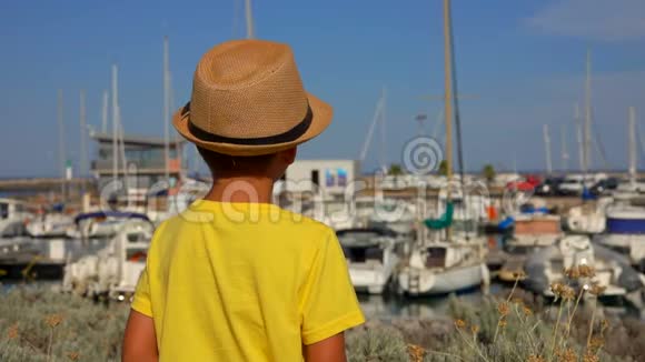 小男孩正在看游艇港口视频的预览图